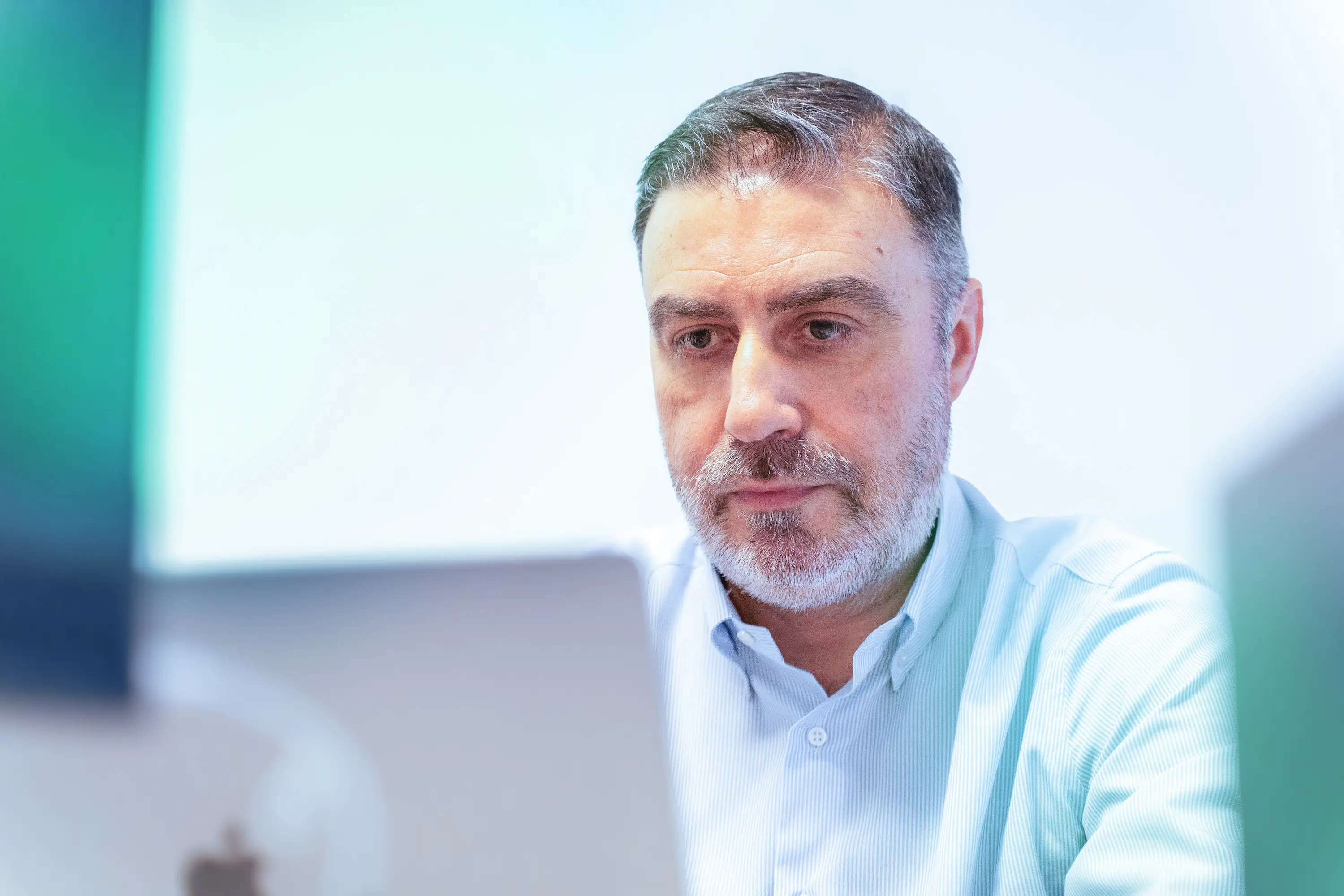 Collaboratore di Winet impegnato nella realizzazione di soluzioni software per Thales, seduto a una scrivania con il laptop in un ufficio moderno e luminoso.