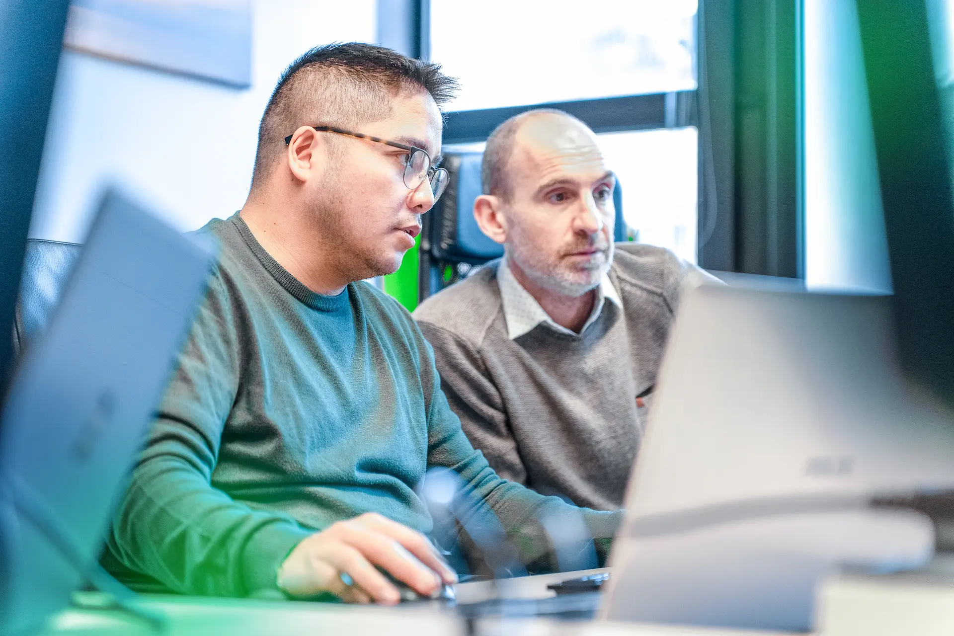 Due professionisti al lavoro su un progetto di consulting software, offrendo un software consulting service mirato alla search intent, come fornito dalle migliori software consulting companies.